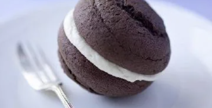 Chocolate sandwich cookie with creme center sitting on a plate
