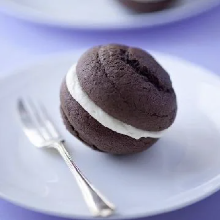 Chocolate sandwich cookie with creme center sitting on a plate