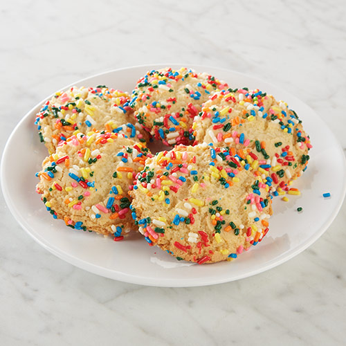 Five chewy cookies with colorful sprinkles on a plate